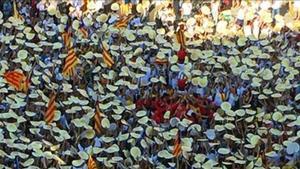 Los manifestantes levantan los puntos de cartulina repartidos por la ANC, en la marcha de Barcelona, a su paso por el paseo de Sant Joan.