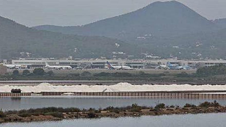 La producción de sal acumulada en un estanque de ses Salines con la vista al fondo de las instalaciones del aeropuerto.