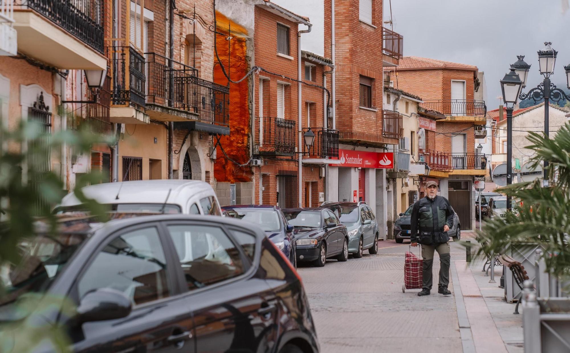 Un vecino de Cenicientos porta la compra en una de las calles principales del municipio.