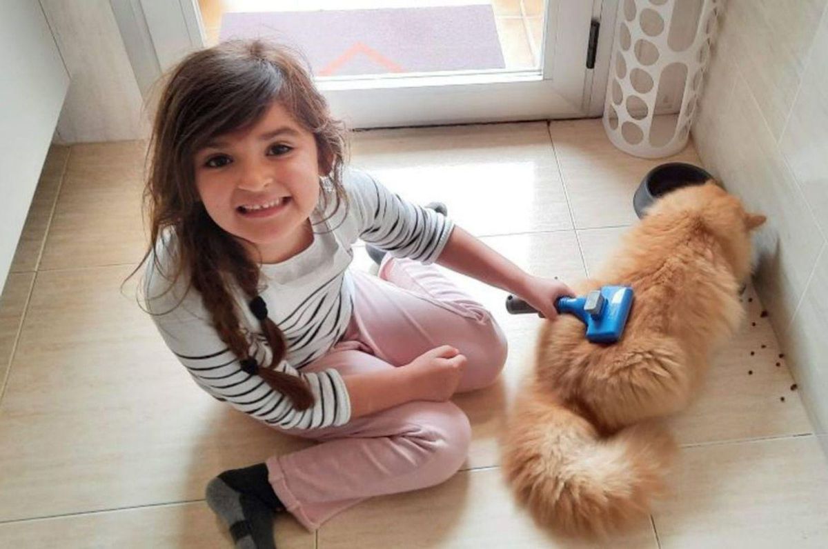 La niña con su mascota y, a la derecha, jugando. | V. C.