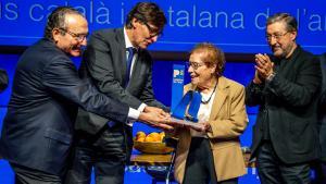 Montserrat Fontané recibe el premio Catalana de lAny de manos de Javier Moll y Salvador Illa, con su hijo Joan Roca a su lado
