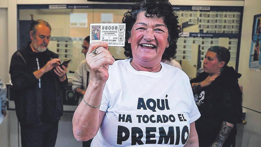 Una de las agraciadas con el 'Gordo' de la Lotería de Navidad sostiene su décimo.