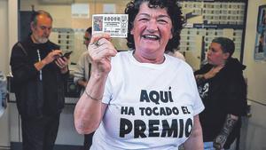 Una de las agraciadas con el Gordo de la Lotería de Navidad sostiene su décimo.