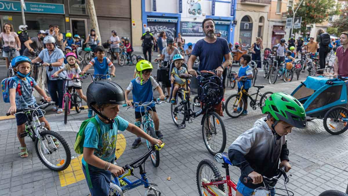 Niños en bicicleta van al cole, por las calles del Eixample.