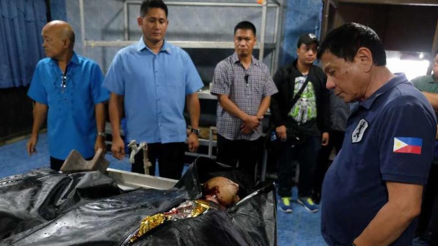 Duterte, al lado de los cadáveres de dos de las catorce víctimas del atentado. // Efe