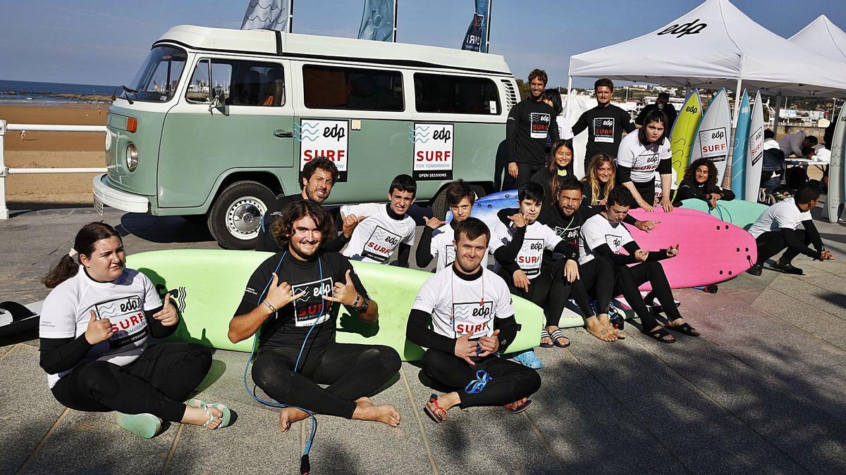 Los monitores y los jóvenes de la asociación Alarde participantes en la jornada de surf inclusivo en la playa de San Lorenzo. | Ángel González