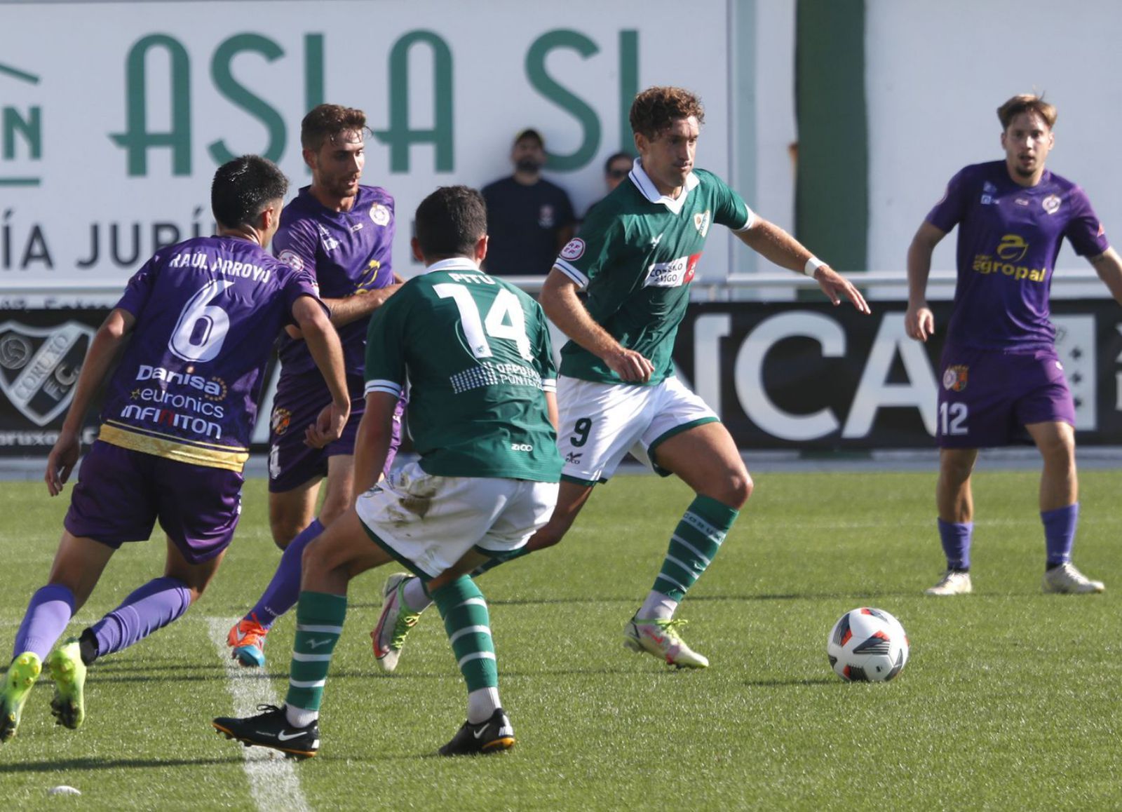 Luismi, del Coruxo, conduce el balón ante la presión de jugadores del Palencia. // RICARDO GROBAS