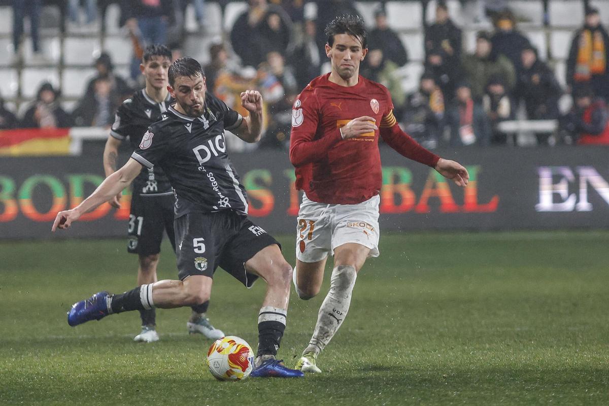 El centrocampista del Burgos Miguel Ángel Atienza (i) lucha con Jesús Vázquez, del Valencia, durante el partido de octavos de final de Copa del Rey que Burgos CF y Valencia CF disputan este jueves en el estadio de El Plantío, en Burgos. EFE/Santi Otero. (Burgos) (Valencia) Añade crónica y fotos