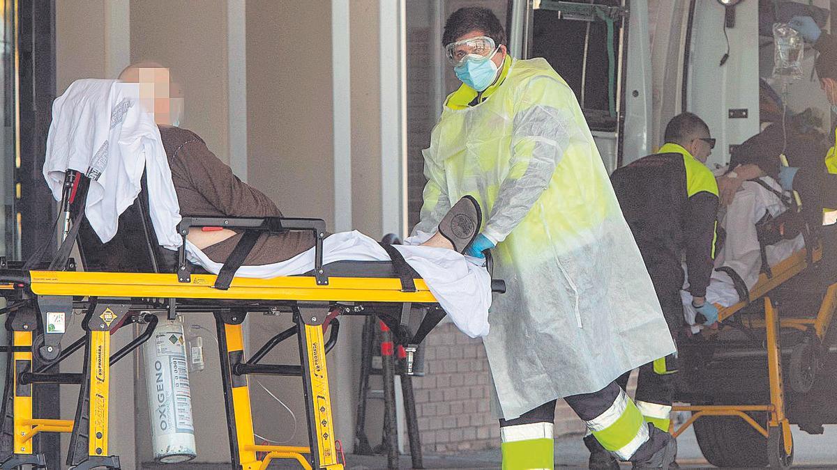 Un sanitario protegido  traslada a un paciente en   el Hospital General