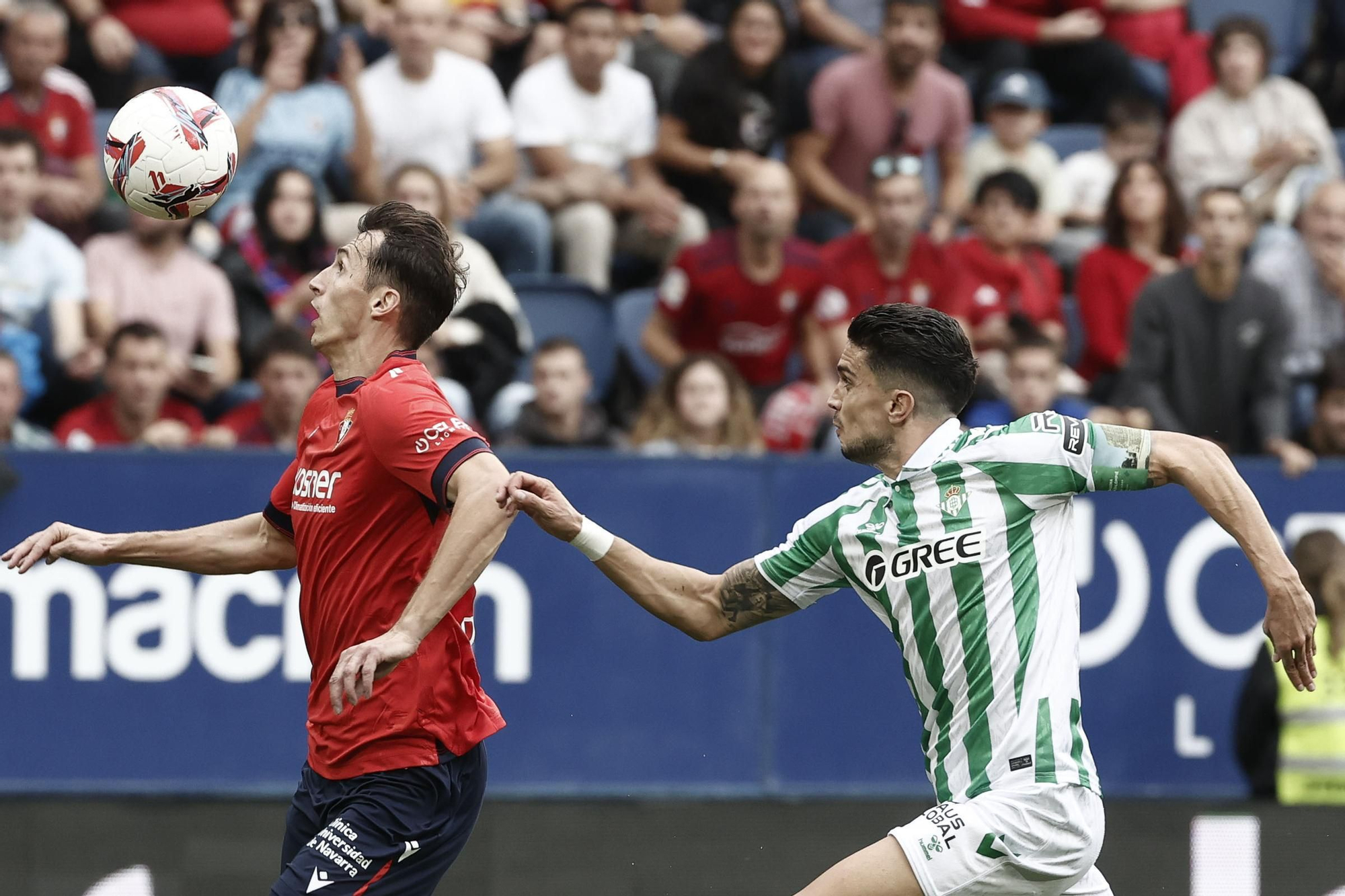 PAMPLONA, 19/10/2024.- El delantero del Osausna Ante Budimir (i) ante el defensa del Betis Marc Barta durante el encuentro correspondiente a la décima jornada de LaLiga entre el Osasuna y el Betis en El Sadar, Pamplona, Navarra, este sábado. EFE/ Jesús Diges