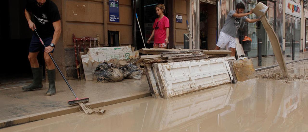 Vecinos sacan agua de sus locales en Orihuela.