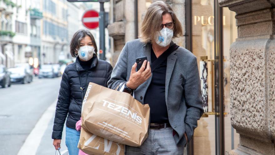Dos personas con mascarillas en Milán.