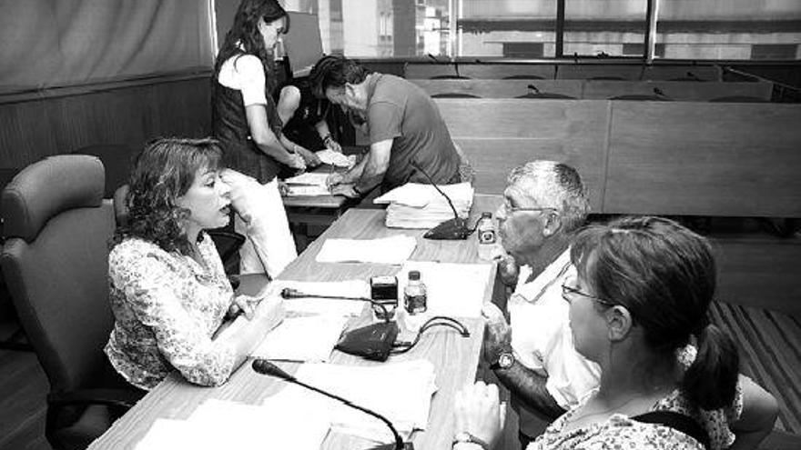 Los afectados llenaron ayer el salón de plenos del Concello de Cangas, donde firmaron los contratos. / Eugenio rouco