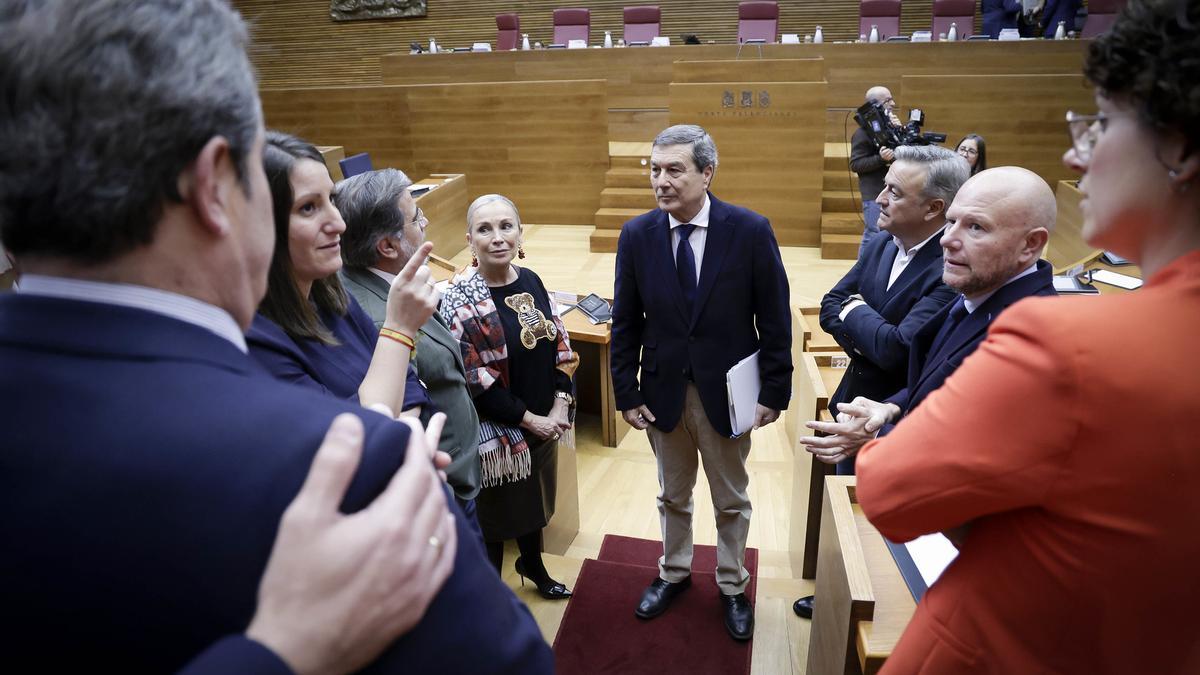 El conseller de Sanidad, Marciano Gómez, habla con varios diputados antes de empezar el pleno del pasado 18 de diciembre.