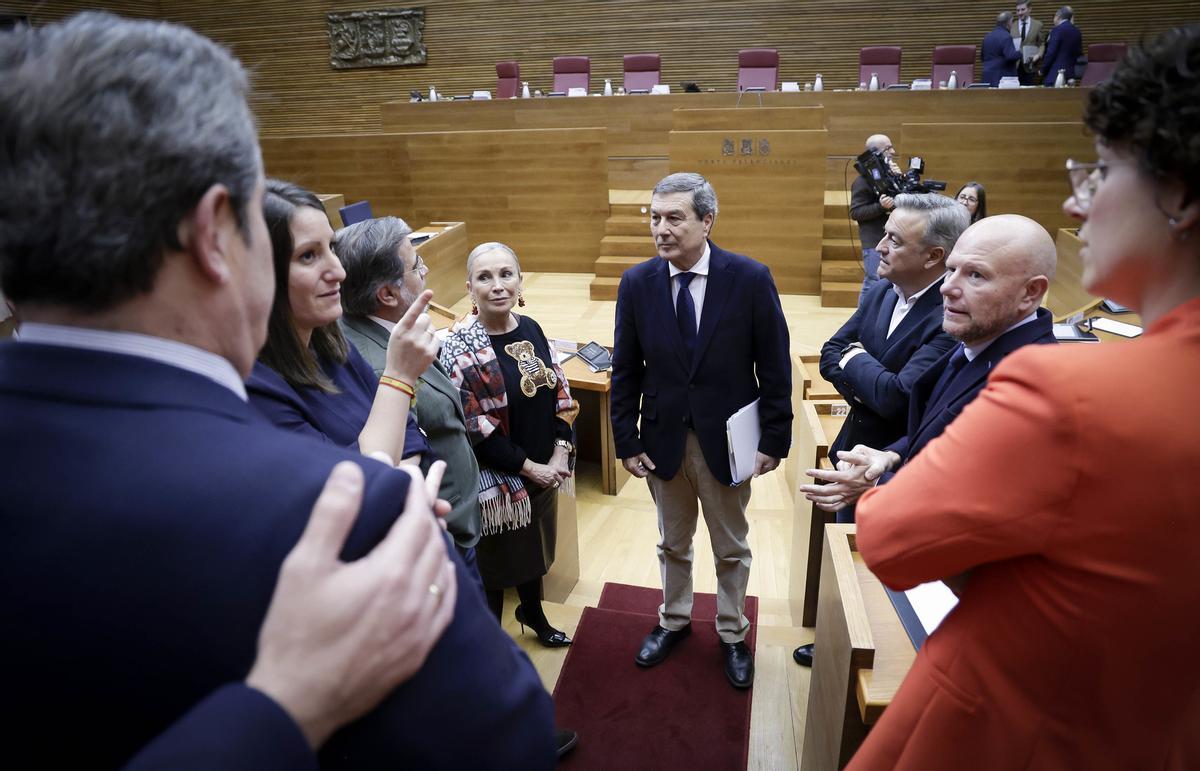 El conseller de Sanidad, Marciano Gómez, habla con varios diputados antes de empezar el pleno.