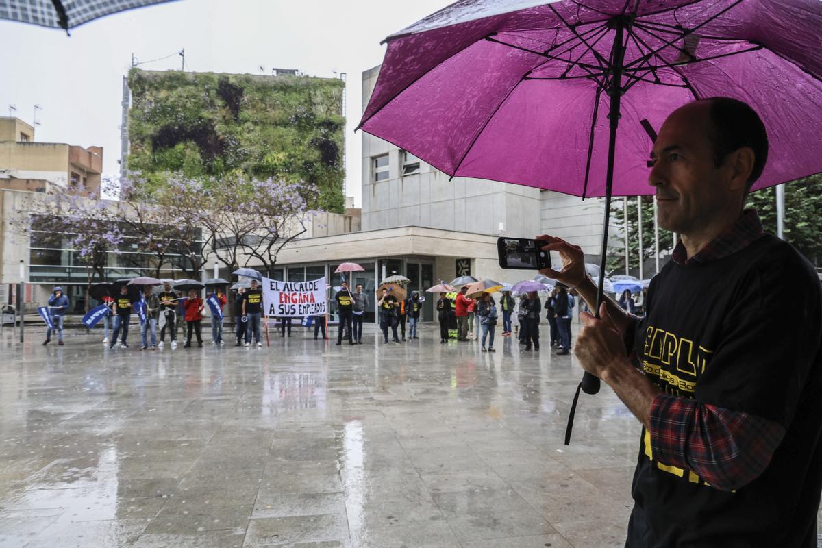 Un trabajador fotografía la protesta, marcada por la lluvia.