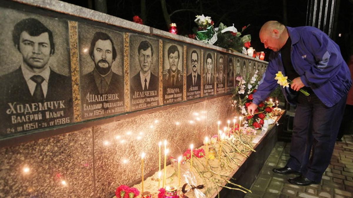 Un ucraniano enciende velas en el memorial en recuerdo de los liquidadores que murieron durante las tareas de limpieza de la central nuclear de Chernóbil, el lunes, en Kiev.