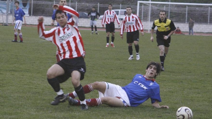 Un jugador del Cobadu es frenado en seco por un rival del Roces en falta