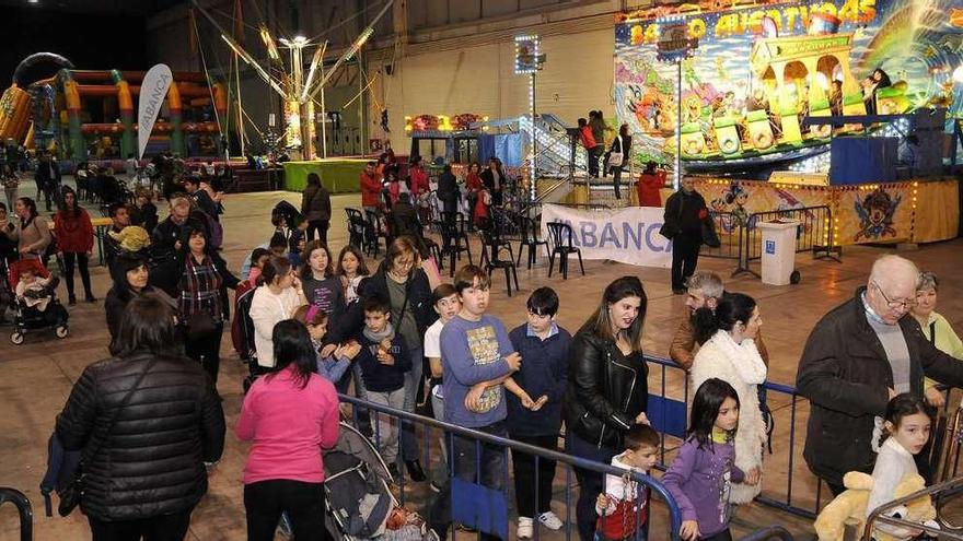 Varios niños, acompañados por mayores, en los coches de choque.  // Bernabé/Javier Lalín