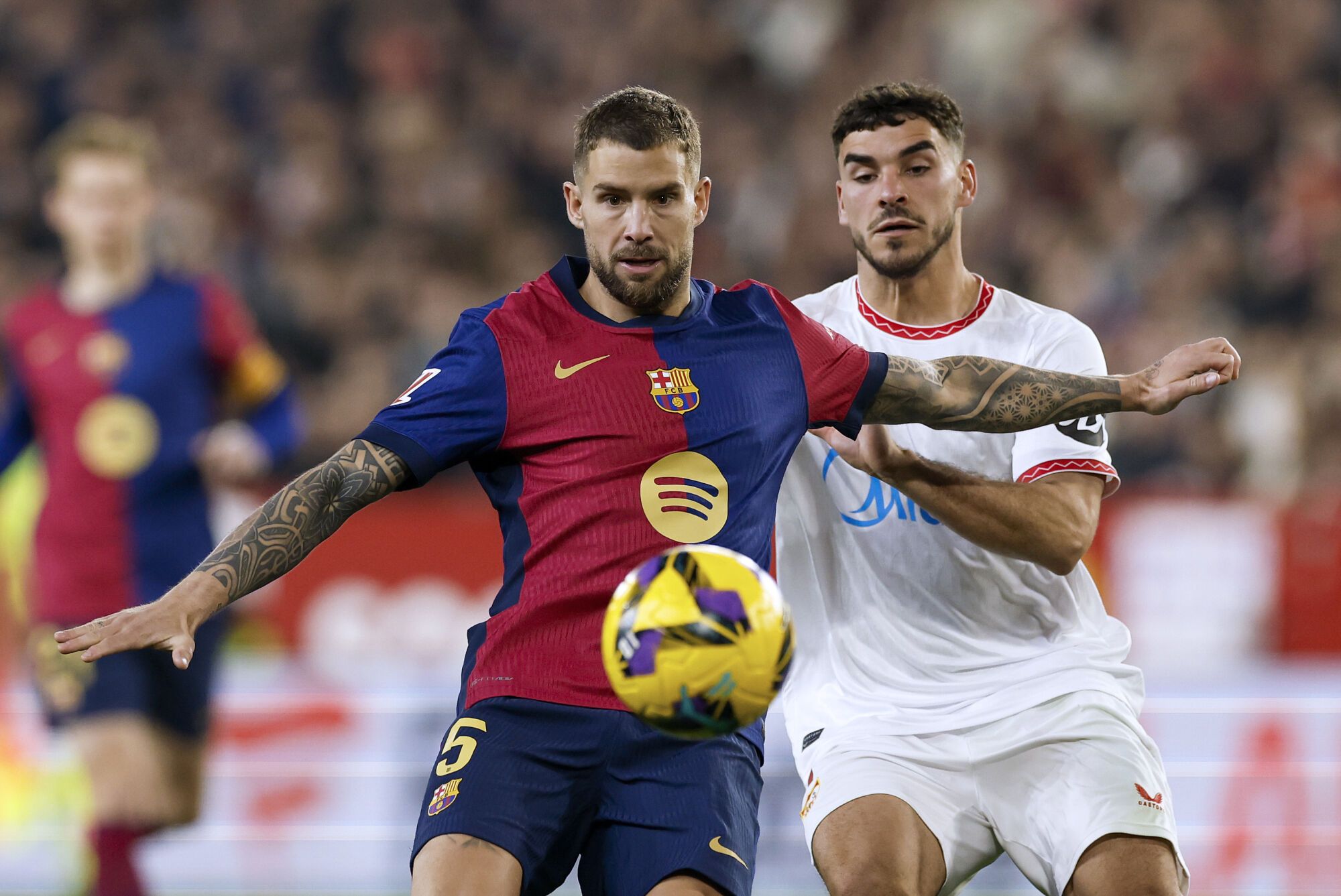 SEVILLA, 09/02/2025.- El delantero del Sevilla Isaac (d) disputa un balón con el defensa del FC Barcelona Iñigo Martínez (d) durante un encuentro correspondiente a la jornada 23 de LaLiga EA Sports entre el Sevilla FC y el FC Barcelona en el estadioo Ramón Sánchez-Pizjuán de Sevilla. EFE/ Julio Muñoz