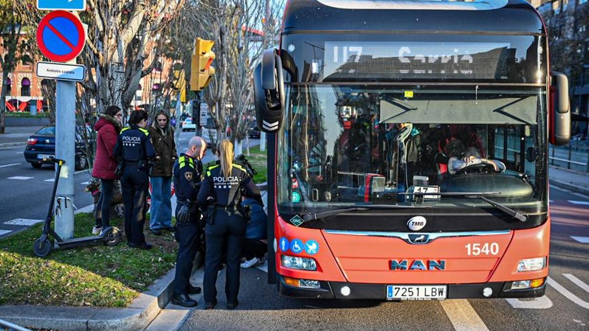 Agentes de la Guardia Urbana atienden a la conductora herida tras chocar con un autobús, en Barcelona.