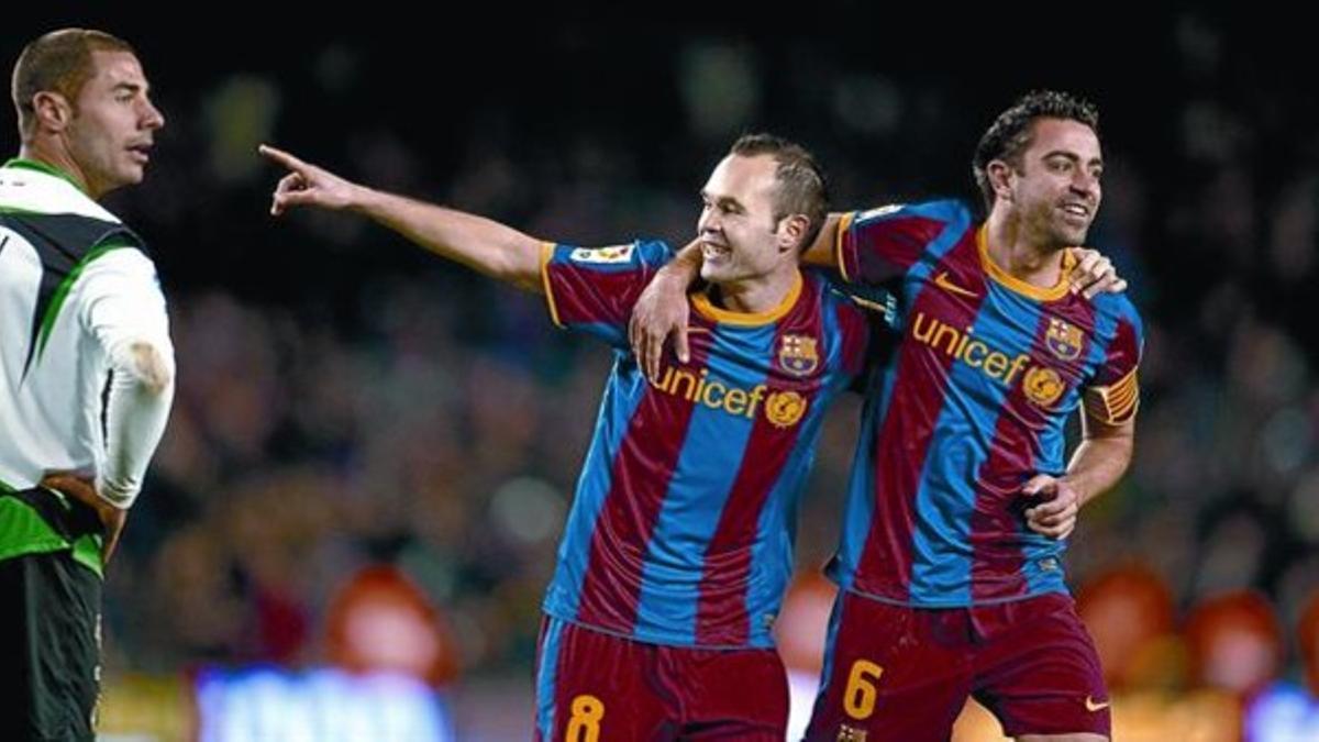 Iniesta celebra abrazado a Xaviel 3-0, después de marcar  contra el Racing, ayer en el Camp Nou.