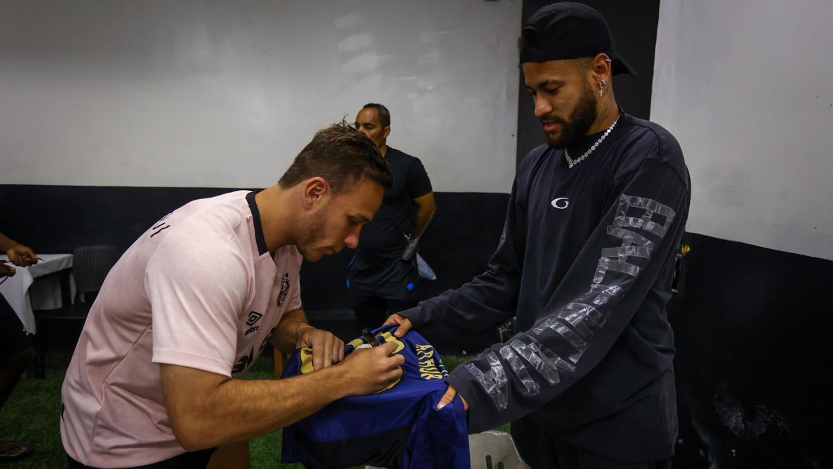 Arthur, firmando la camiseta que regaló a Neymar