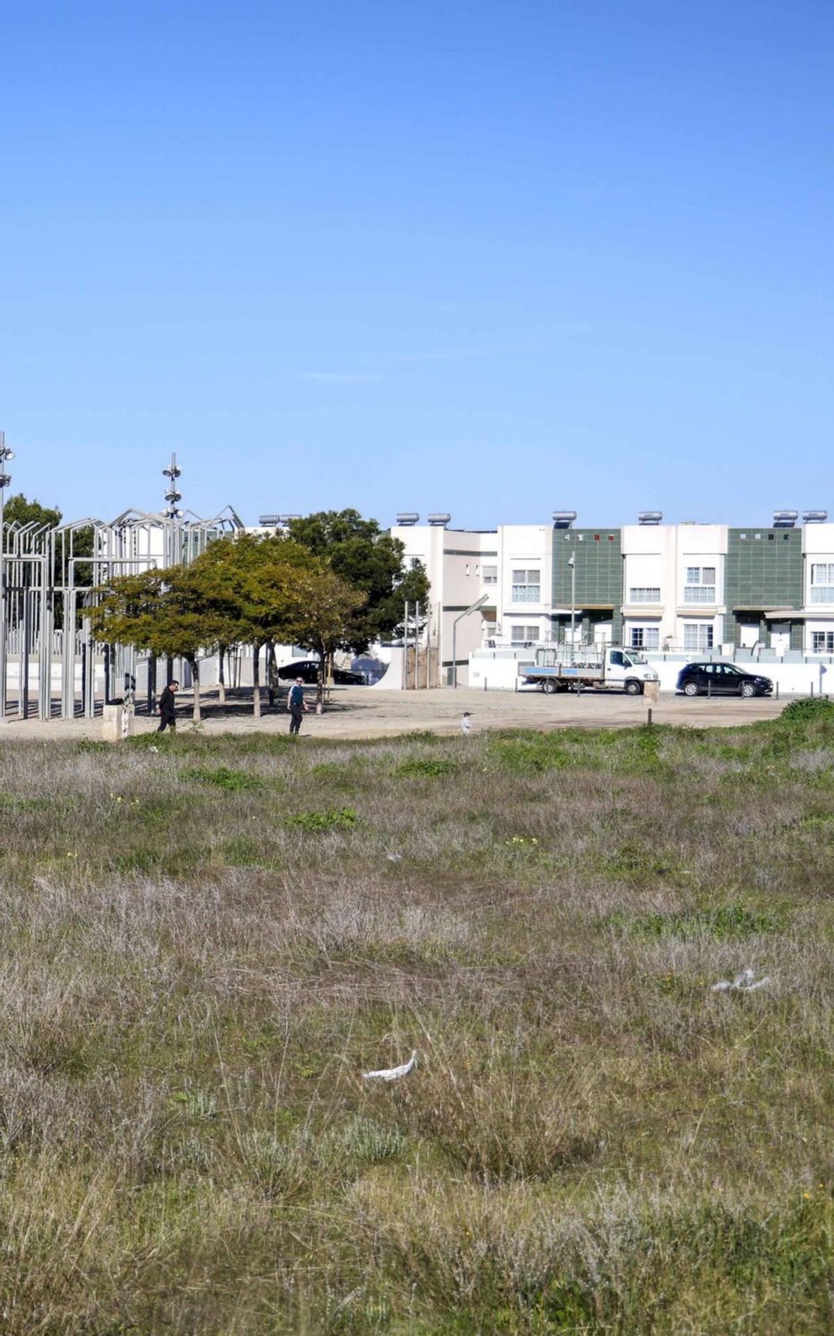 Un solar sin urbanizar en El Algar con casas de fondo.