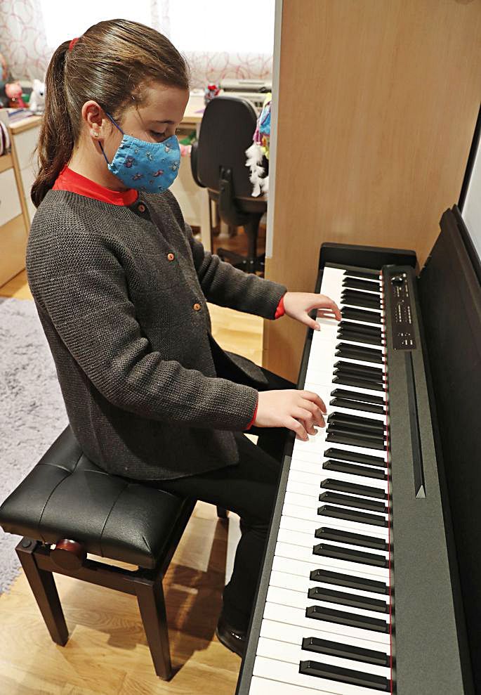 Xabela, ensayando al piano en su cuarto y escribiendo en braille con su máquina Perkins.