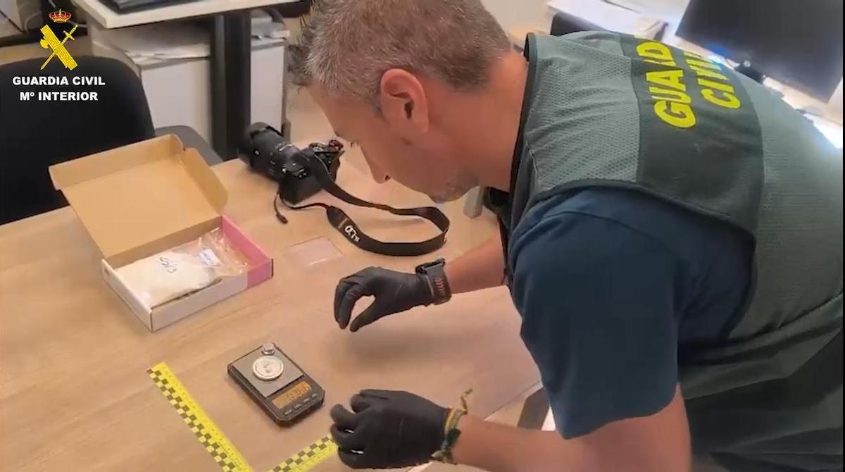 Un guardia civil mide una báscula de precisión incautada a los camellos de flakka en Valencia.