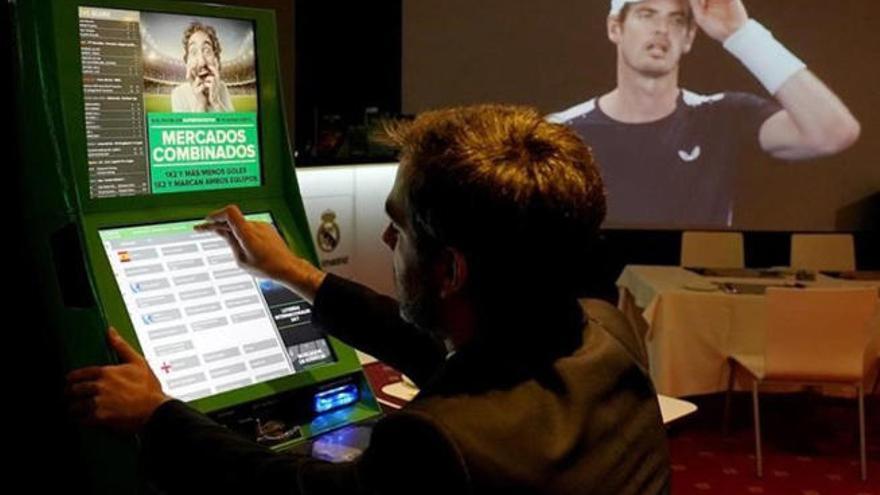 Un joven juega a las apuestas deportivas en un salón recreativo en una imagen de archivo.