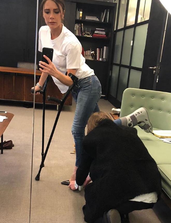 Victoria Beckham probándose un tacón a la pata coja