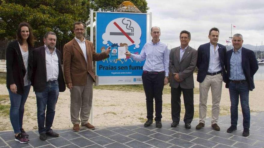 Jesús Vázquez Almuiña entrega el diploma al alcalde, Ángel Rodal, ayer, en la playa de Ribeira. // FdV