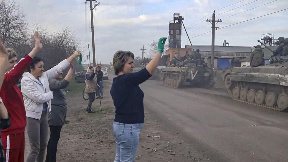 Dones ucraïneses saluden els militars russos a Khàrkiv en una foto divulgada pel Kremlin. | EFE