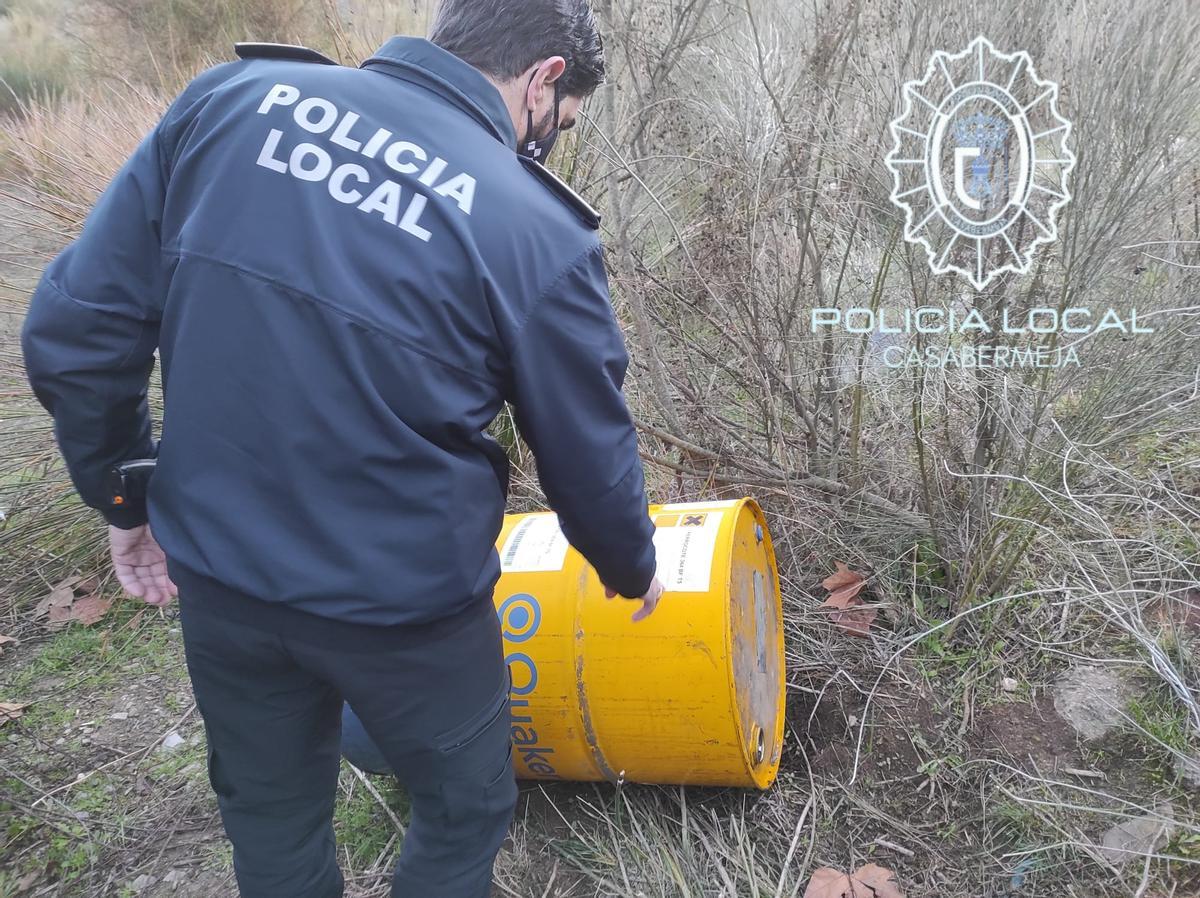 Agente de la Policía Local de Nerja junto a un bidón de aceite anticorrosivo.