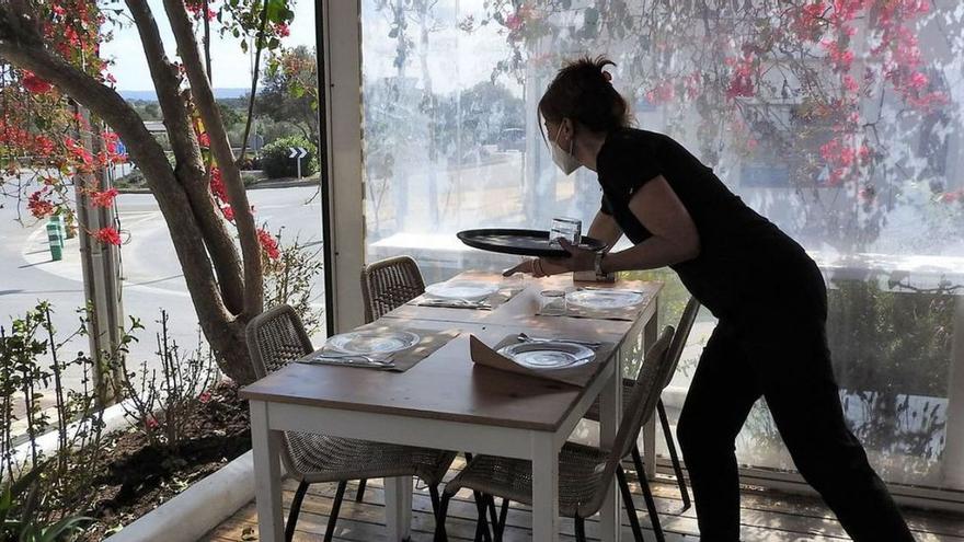 Una camarera prepara una mesa en una terraza de un restaurante de Sant Francesc.