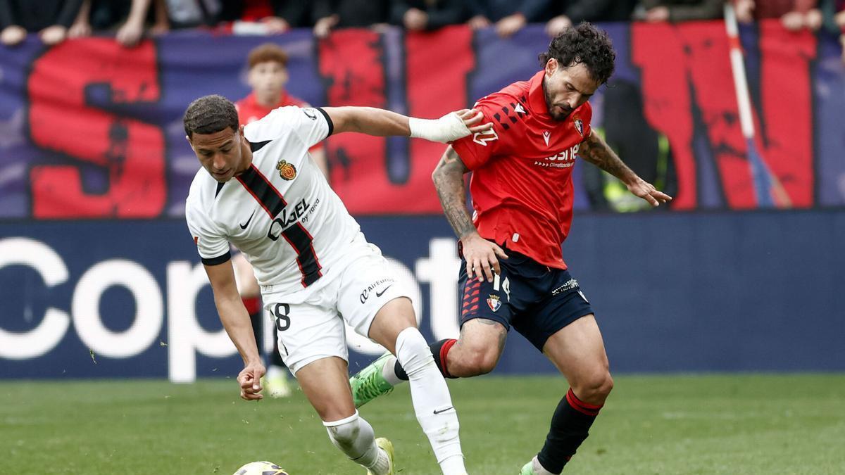 El centrocampista del RCD Mallorca Mateo Joseph Fernández (i) con el balón ante el cetntrocampista del Osasuna Rubén García durante el partido de Liga que Osasuna y Mallorca disputan este sábado en el estadio de El Sadar, en Pamplona.