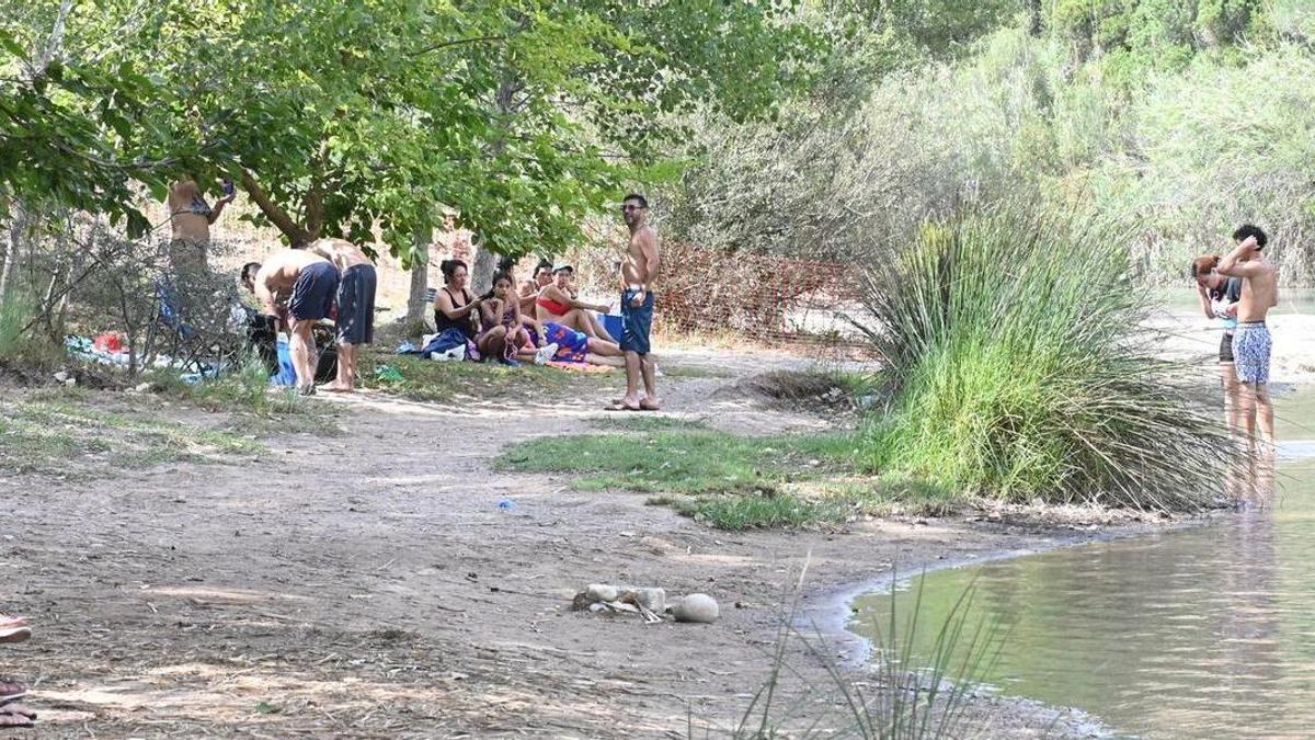 nes persones gaudeixen de la platja del Millars i prenen el bany al riu en el paratge del Termet de Vila-real.