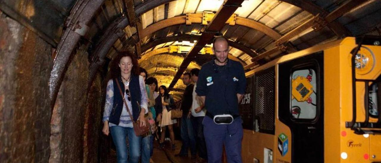 Un grupo de turistas, bajando del tren para ascender al pozo San Luis.