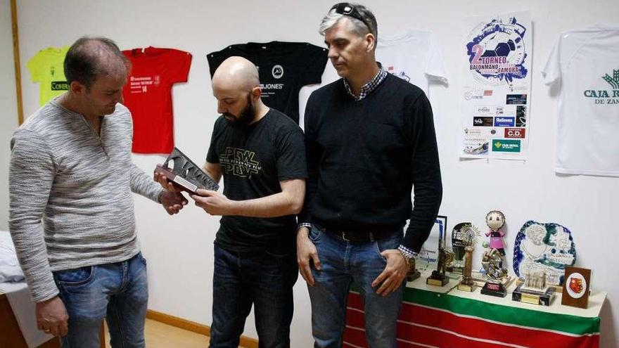 Entrenador y junta directiva de La Muralla de Zamora posa junto al cartel del torneo con el trofeo en la mano.