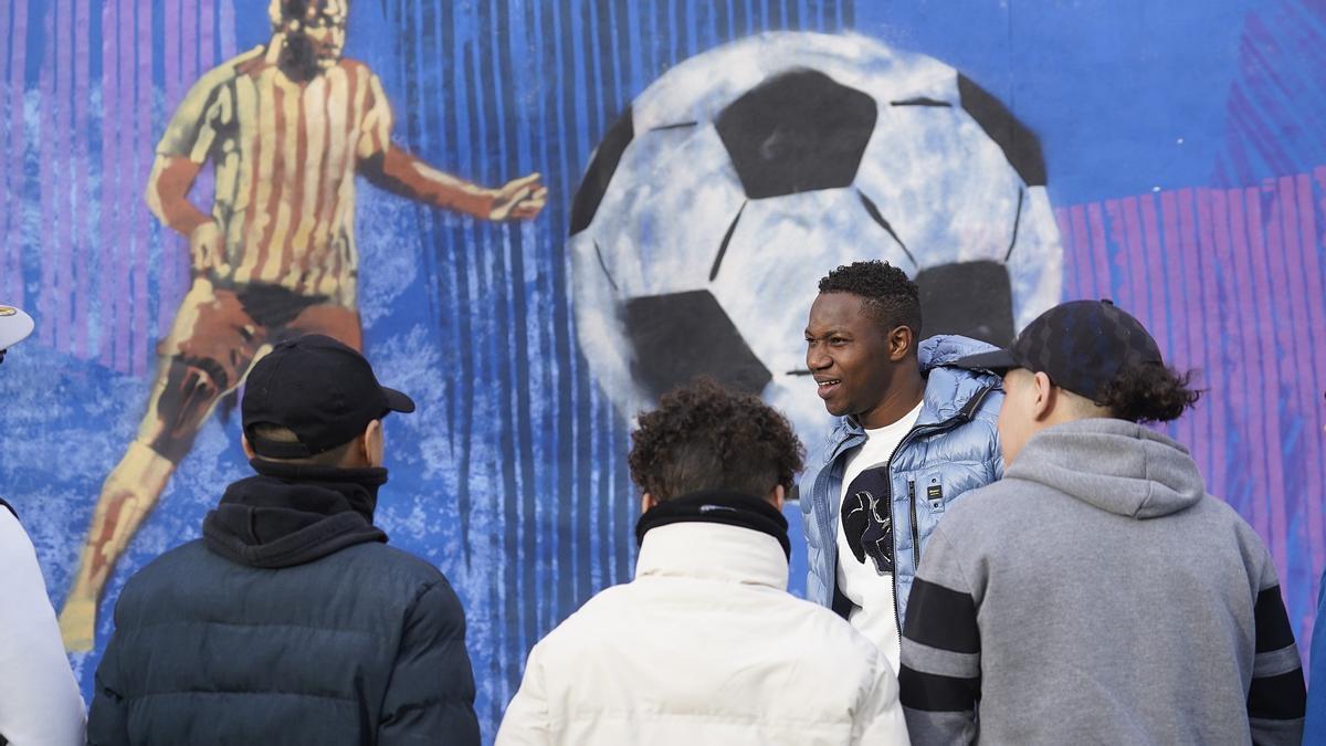 Kebé, amb el mural que van pintar-li els interns al pati del centre