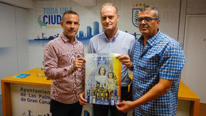 David Sánchez, Sergio Millares y José Falcón sosteniendo el cartel de las Fiestas del Carmen