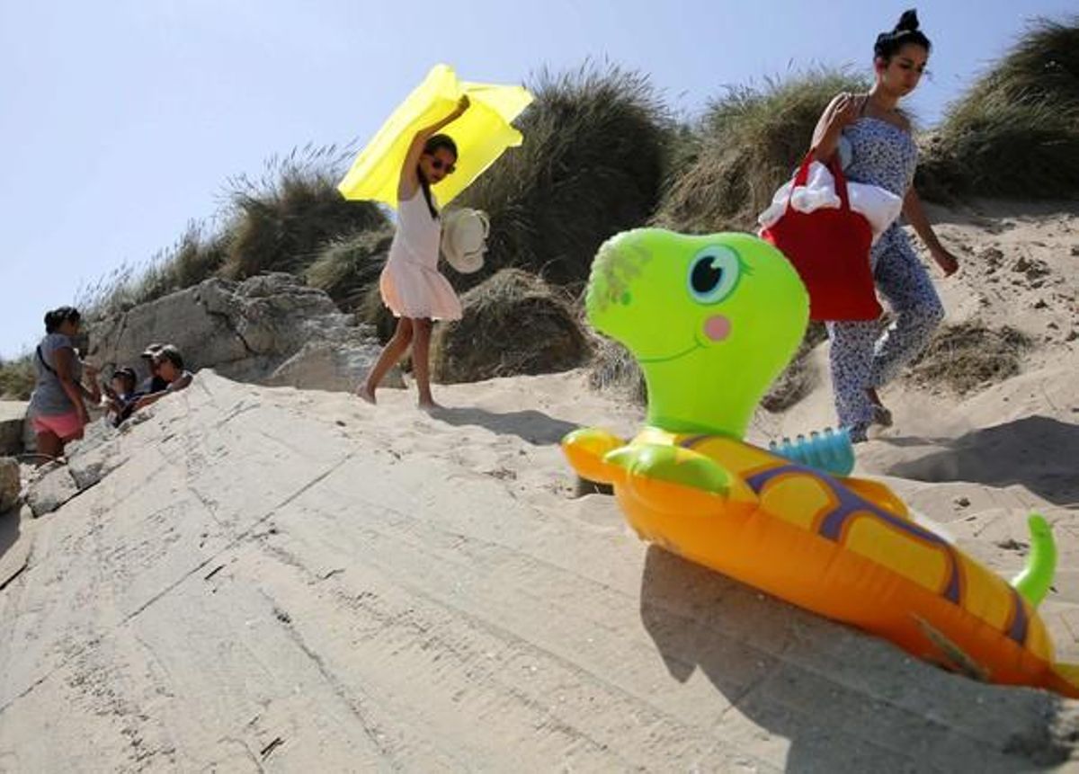 Turistes en una duna de la platja de Utah, a prop de La Madeleine, l’any passat.