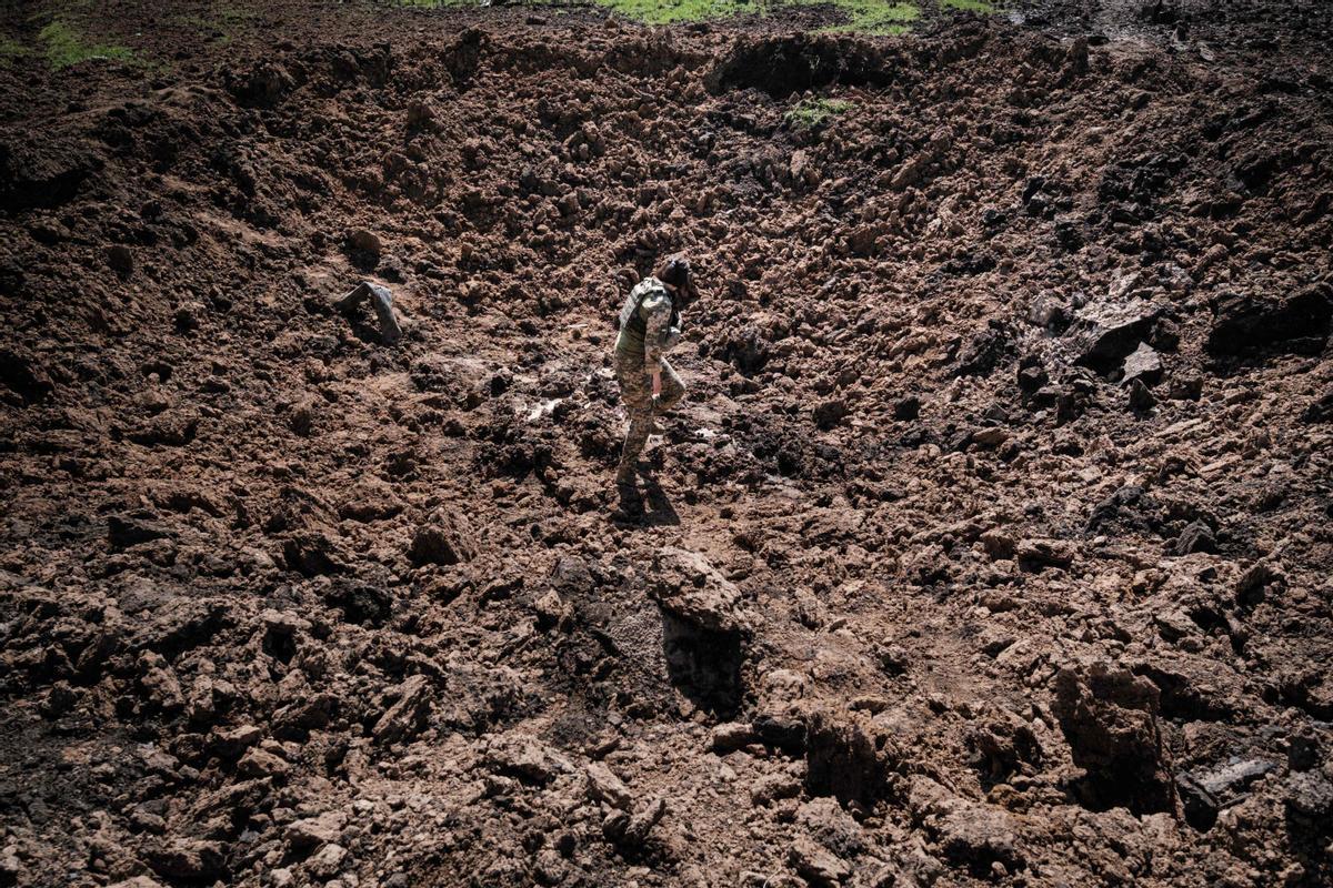 Un militar ucraniano en un cráter producido p misiles rusos en Bohodarove, este de Ucrania