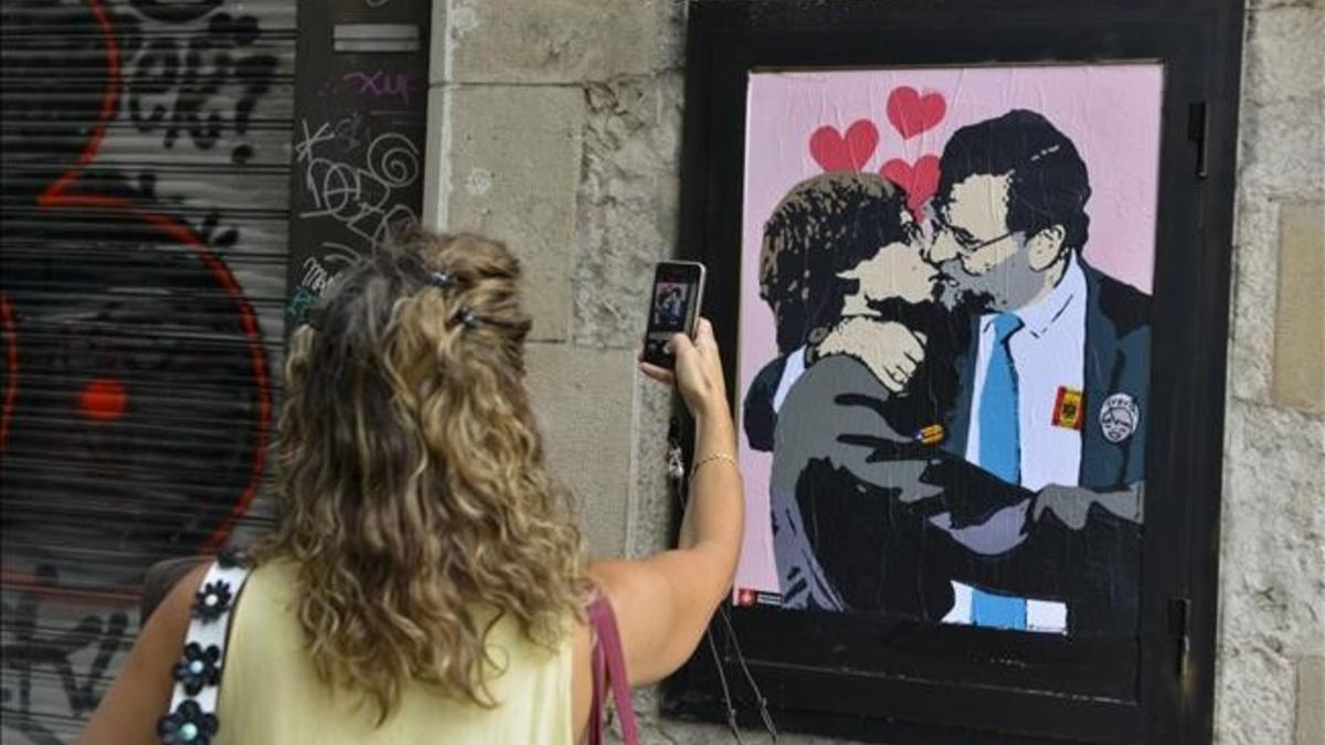 Grafiti de beso Rajoy Puigdemont en la Pl de Sant Jaume