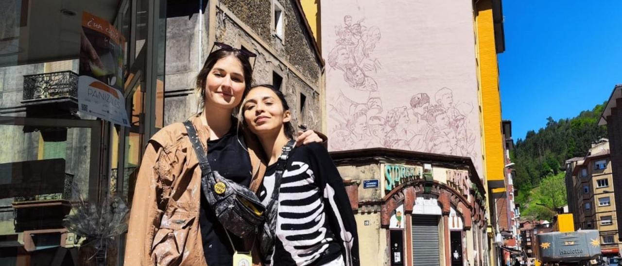 Natalia Andreoli y Lina Castellanos, ayer ante el mural que están pintando en Mieres. | A.V.