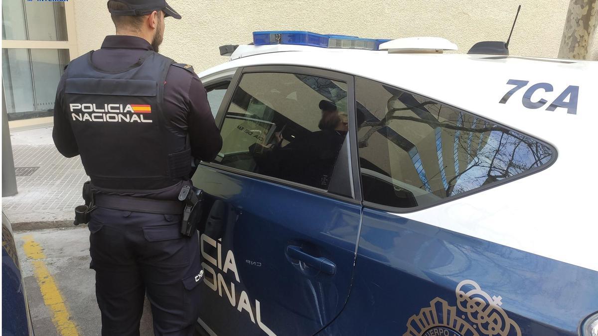 Un agente junto a un vehículo de la Policía Nacional.