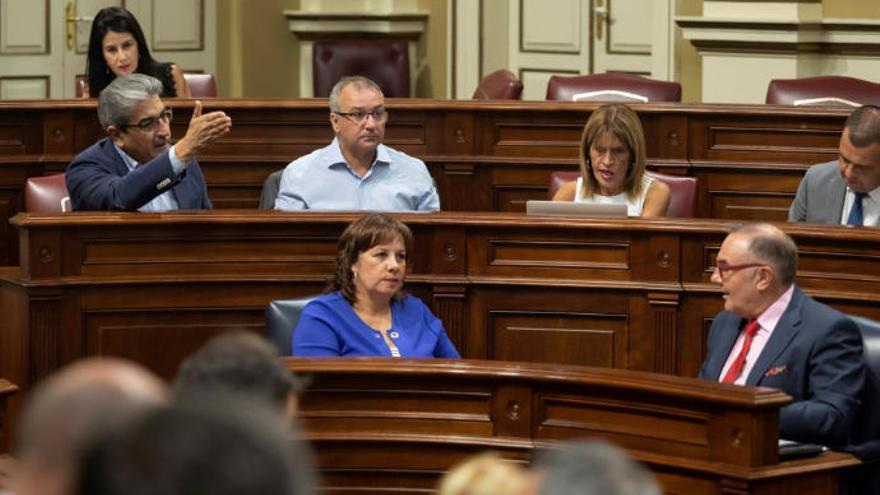 El diputado de Nueva Canarias, Román Rodríguez, se dirige al consejero de Sanidad del Gobierno de Canarias, José Manuel Baltar, y a la consejera de Educación, Soledad Monzón,durante el pleno del Parlamento de Canarias.