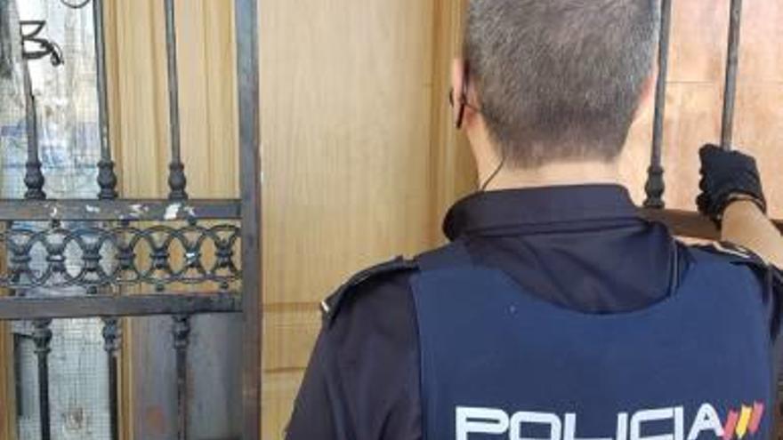 Un policía en la puerta de una de las casas registradas.