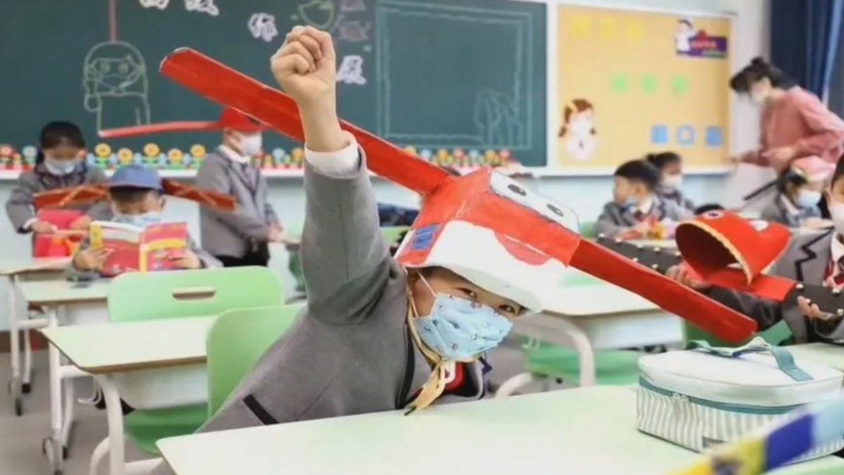 Los niños chinos aprenden distancia social usando sombreros con alas